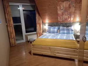 een slaapkamer met een bed met een houten muur bij KATI VILLA-BEACH in Balatonlelle