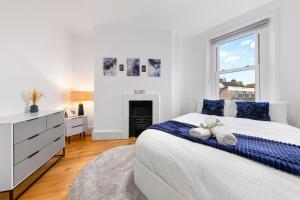 a white bedroom with a bed and a window at Stunning apartment in Kings Cross sleeps 10 in London