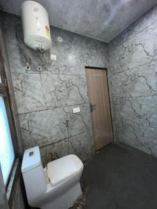 a bathroom with a toilet and a light on the wall at Hotel Super Residency - Nizamuddin in New Delhi