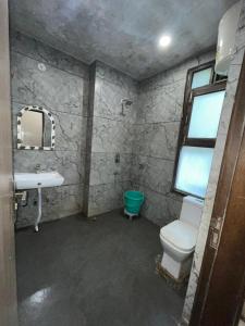 a bathroom with a toilet and a sink and a window at Hotel Super Residency - Nizamuddin in New Delhi