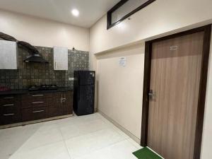 a kitchen with a refrigerator and a door in it at Hotel Super Residency - Nizamuddin in New Delhi