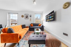 ein Wohnzimmer mit orangefarbenen Möbeln und einer Treppe in der Unterkunft Stunning apartment in Kings Cross sleeps 10 in London