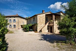 a large stone building with a driveway in front of it at Apartment in Casole d'Elsa - Toskana 24073 in Casole dʼElsa