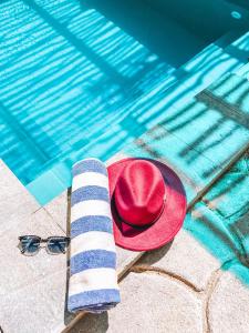 a red hat and sunglasses next to a swimming pool at Private Pool Cabanas AC - Angam Villas Hikkaduwa in Hikkaduwa