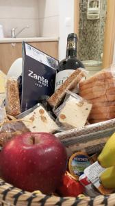 - un panier de nourriture avec une pomme, du pain et une bouteille de vin dans l'établissement Meltemaki, à Mouzákion