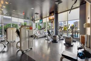 um ginásio com equipamento cardiovascular num edifício com janelas em Amazing Pool - Apartment with Balcony and Gym em Hallandale Beach