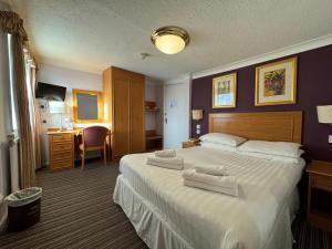 a hotel room with a large bed with towels on it at The Chatsworth Hotel in Worthing