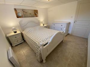 1 dormitorio con 1 cama blanca y 2 mesitas de noche en L’Olivier en Grignan