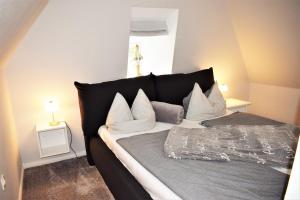 a bed with a black headboard and white pillows at Heimathafen in Bordelum