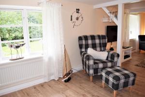 a living room with a chair and a tv at Heimathafen in Bordelum