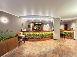 a lobby with a bar with plants on the wall at Hotel Orbita in Varna City