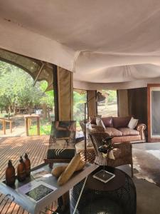 sala de estar con sofá y mesa en Karongwe Portfolio - Chisomo Safari Camp, en Karongwe Game Reserve