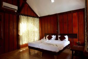 a bedroom with a large bed with white sheets at Sahyadri Pride in Wai
