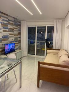 Schlafzimmer mit einem Bett und einem Schreibtisch mit einem TV in der Unterkunft Makaiba Residence 003 in Porto De Galinhas