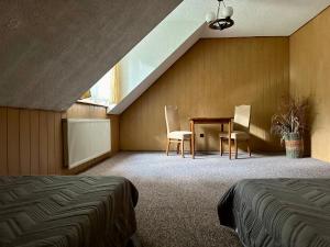 オルシュティネクにあるLeśna Chataのベッドルーム1室(ベッド1台、テーブル、椅子付)