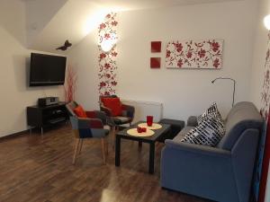 sala de estar con sofá, sillas y TV en Wikingerland Typ 1 Erdgeschoss, en Langballig