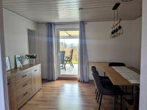 a kitchen and dining room with a table and a sliding glass door at Hexenhaus in Sankt Wendel