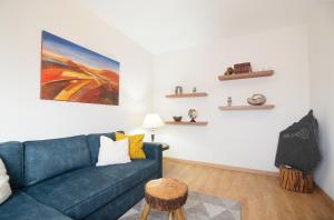 ein Wohnzimmer mit einem blauen Sofa und einem Tisch in der Unterkunft PortoMar House Apartament in Leça da Palmeira