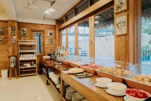una cucina con un lungo bancone con prodotti alimentari di U OLIVE Hotel a Ban Nua