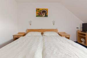 a bedroom with a bed with white sheets and a tv at Turistična kmetija Protner in Pernica +17 photos