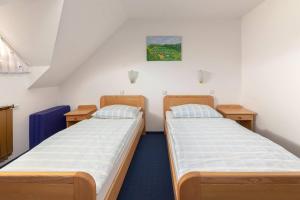 Turistična kmetija Protner في Pernica: سريرين في غرفة صغيرة مع سرير إضافي
