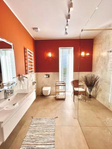 Łazienka z pomarańczowymi ścianami i przeszkloną kabiną prysznicową w obiekcie Leo House w mieście Gdynia