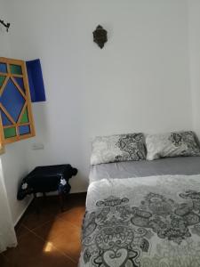 um quarto com uma cama e um saco preto no chão em Dar issam em Chefchaouen