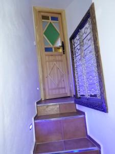 a staircase with a wooden door and a window at Dar issam in Chefchaouene