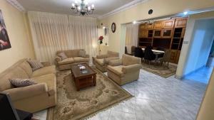 sala de estar con sofás y comedor en New Cozy Apartment 5 Minutes away from Cairo Airport and all Amenties en El Cairo