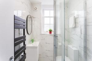 a bathroom with a shower and a toilet and a sink at City Centre One Bedroom Apartment Next to Station, Newly Renovated in London