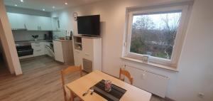 a kitchen and dining room with a table and a window at Ferienwohnung Strandjuwel am Strand in Norddeich +13 photos