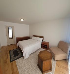 a bedroom with a bed and a couch and a chair at Traveler's Lodge In Newark City in Newark