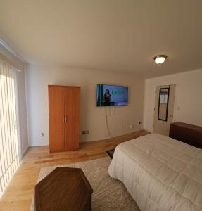 ein Schlafzimmer mit einem Bett und einem TV an der Wand in der Unterkunft Traveler's Lodge In Newark City in Newark
