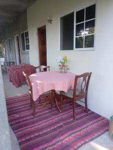 einen rosa Tisch und Stühle auf einem Teppich auf einer Terrasse in der Unterkunft Barracuda beach in Port Antonio