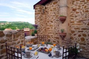 una mesa con comida en el patio en Les Terrasses Dorées - Chambres d'hôtes de charme & Jacuzzi, en Châtillon