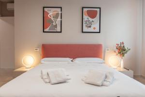 een slaapkamer met een groot wit bed met twee lampen bij La Casa di Duccio in Perugia