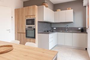 een keuken met witte kasten en een houten tafel bij La Casa di Duccio in Perugia