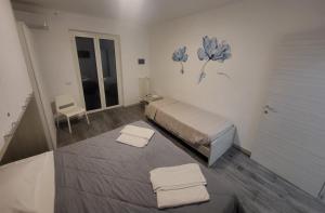 sypialnia z łóżkiem i 2 ręcznikami na podłodze w obiekcie Santa Maria Vetere w mieście Andria