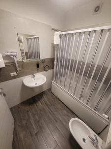 W łazience znajduje się umywalka, toaleta i lustro. w obiekcie Santa Maria Vetere w mieście Andria