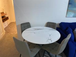 a white table and chairs in a living room at Convenient 2 Bedroom Ground floor Apartment with Parking in Leeds in Pudsey