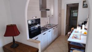 a kitchen with a stove and a sink and a table at Peppe House in Casal Palocco