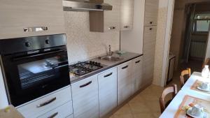 a kitchen with a stove and a sink at Peppe House in Casal Palocco