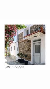 un edificio blanco con ventana y pared de piedra en EvageliasVilla sea view en Skopelos Town