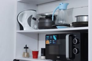een aanrecht met een magnetron en enkele potten en pannen bij Anga Nest a chic One-Bedroom Ngong Road in Nairobi