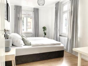um quarto branco com uma cama e janelas em *Ferienwohnung in Schwarzwald Villa für 6 Pers.* em Furtwangen