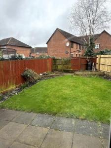 a backyard with a fence and a yard with green grass at Cosy family 3-bedroom Home in Simpson