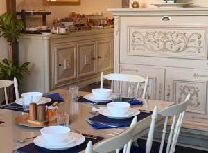 einen Esstisch mit blauen Servietten und weißen Gerichten in der Unterkunft Chateau de Chambres Mont St Michel in Saint-James
