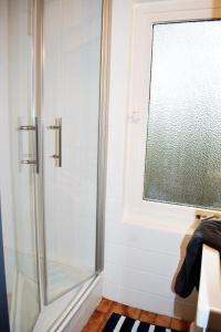 um chuveiro com uma porta de vidro na casa de banho em Villa Lullyhill em Bargum