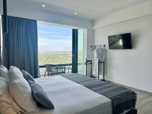 a bedroom with a large bed with a large window at Habitat Inn Faliraki View Villa Rhodes in Kalithies