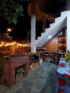 an outdoor kitchen with a stone fireplace at night at Hospedaje Puro JIta Lunahuaná Departamento vacacional in San Vicente de Cañete